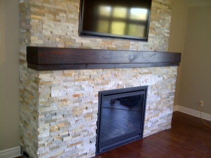 interior fireplace with brick pattern enclosure wooden shelf and mounted flat screen tv